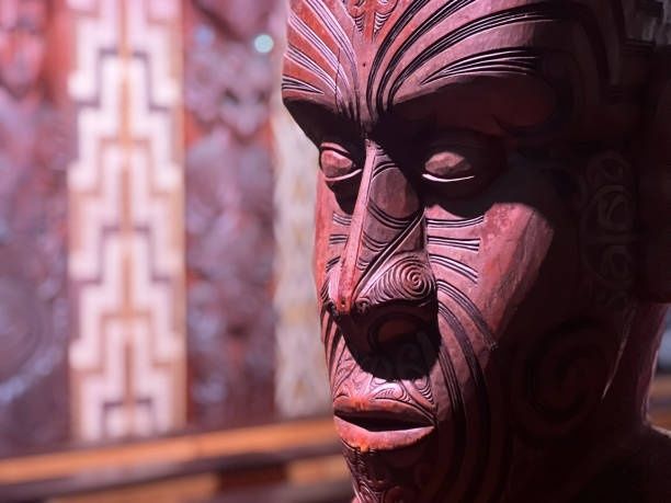 Nahaufnahme einer geschnitzten Māori-Figur mit markanten Gesichtsmotiven